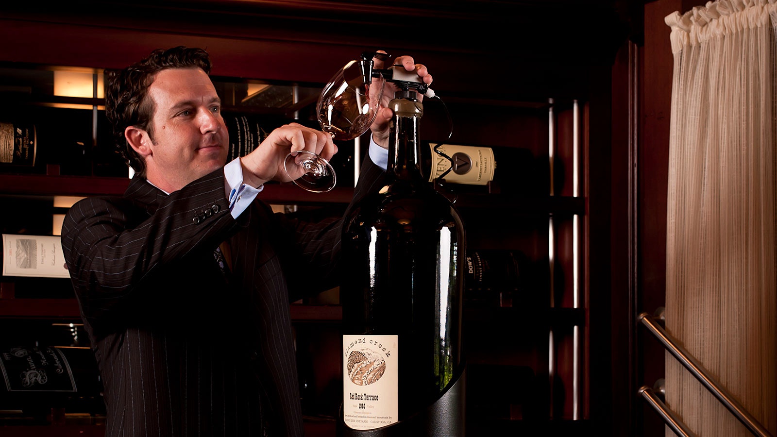 Robert Smith using a Coravin system to pour red wine from a large-format bottle into a glass
